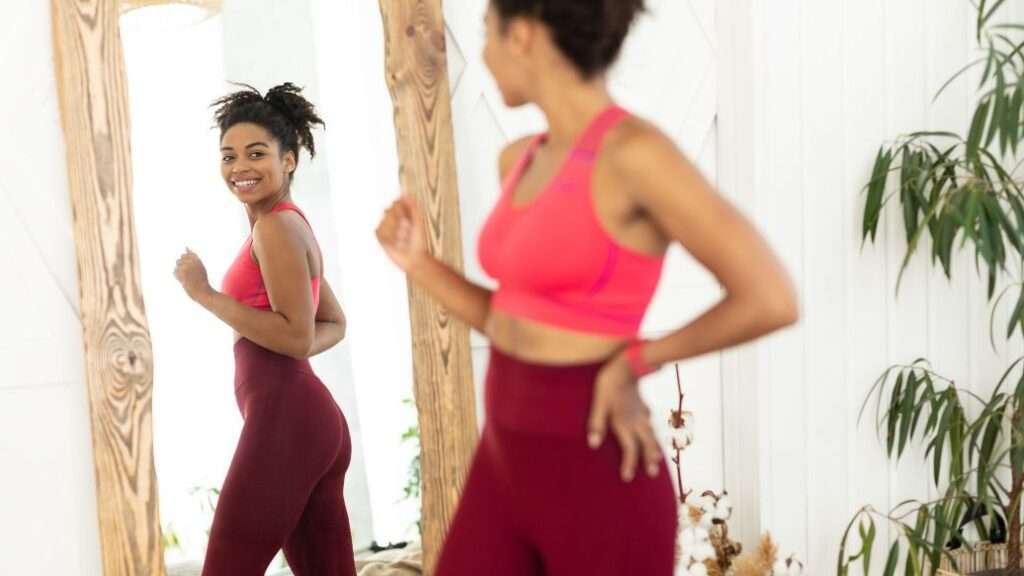 Woman looking at her weight loss in a mirror